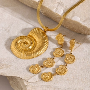 Macro shot of 18k gold plated stainless steel nautilus shell necklace and earring set