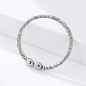 Macro detail of silver twisted rope texture and polished ball ends on magnetic steel bangle