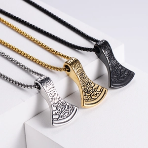 Detailed view of Viking axe pendants in silver, gold, and black on geometric pedestals