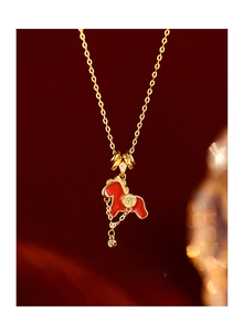 Detail of red enamel zodiac horse pendant with gold plating and sparkling tassel fringe