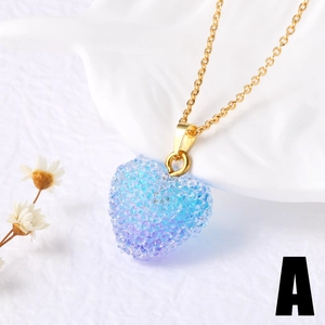 Gros plan du pendentif cœur en dégradé bleu avec cristaux sur chaîne dorée