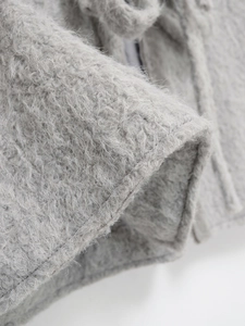 Detailansicht der weichen hellgrauen Wollstofftextur für Herbst-Winter-Mäntel