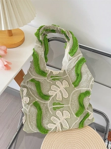 Sac sous le bras rétro en dentelle florale avec franges 3D sur une chaise métallique