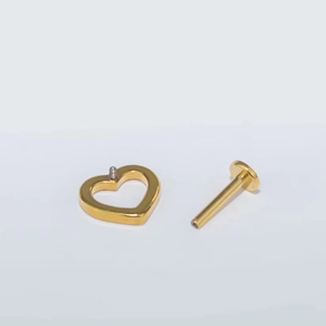 Detailed macro view of the gold G23 titanium heart labret stud with internal threading