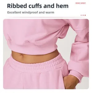 Detail of ribbed cuffs and hem on pink cropped hoodie ensuring windproof warmth