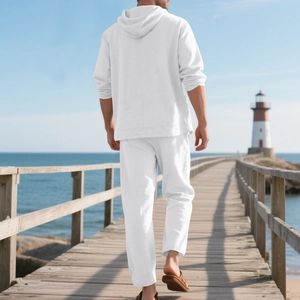 Men's white linen beach set with hoodie and pants shown in a scenic coastal outdoor view