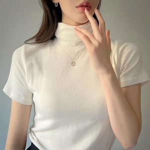 Close-up of minimalist 925 sterling silver hoop earrings on a model wearing a white knit top