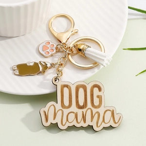 Detail of wooden DOG mama keychain with corgi charm, paw print, and white tassel