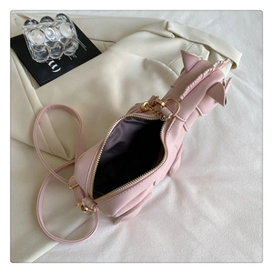 Detail view of pink unicorn cross-body bag with golden zipper and dark fabric lining