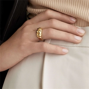 Detailed close-up of a 18K gold-plated twisted croissant ring on model's finger
