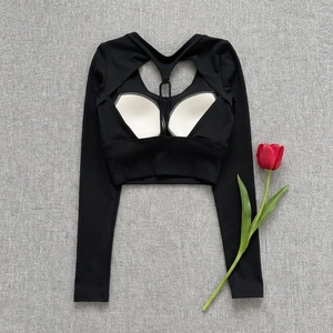 Detail view of black long sleeve yoga crop top with back cutout and white padding