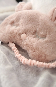 Close-up of pink plush bunny eye mask featuring soft faux fur and elastic headband