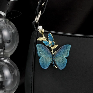 Elegant embroidered blue butterfly brooch with pearls and rhinestones on black leather