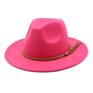 Detail of rose red wool fedora hat featuring a brown woven band with tassel accents