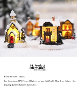 Close-up of glowing miniature Christmas house with snowy roof and warm internal LED light