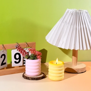 Detalle del molde de silicona con textura de ondas para maceta rosa y portavelas amarillo