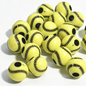 Macro view of yellow acrylic baseball beads with black stitching and central threading holes