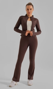Détail du pantalon évasé taille haute et de la veste slim dans un ensemble de sport marron