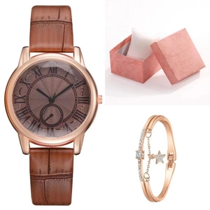 Detalle del reloj de oro rosa con números romanos y pulsera de estrella en estuche