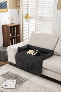Close-up of black quilted water-resistant pet sofa cover with protective bolsters