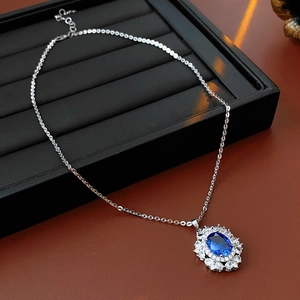 Dettaglio di una collana vintage con ciondolo ovale blu in una scatola di velluto