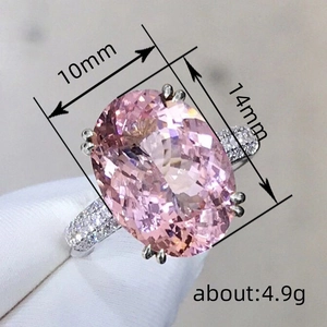 Oval pink sapphire ring in silver four-prong setting with micro-pave white side stones