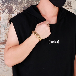 Detail of punk style golden multi-layer chain bracelet with embossed wolf charm on wrist