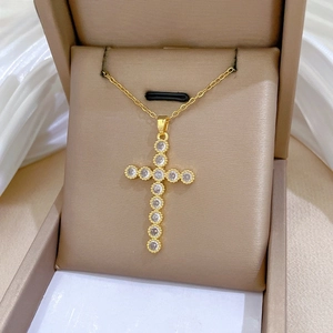 Macro shot of gold cross necklace with shimmering white zircons in a premium jewelry box