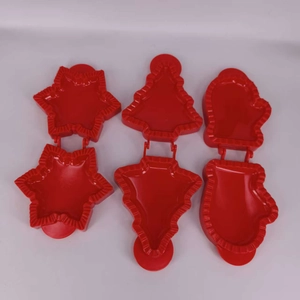 Detail of red 3D Christmas cookie cutters in star, tree, and glove shapes for baking
