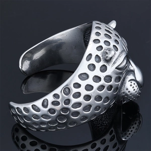 Detailed close-up of a silver stainless steel leopard head bangle with textured spots