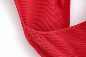 Dettaglio ravvicinato del tessuto in maglia a coste rosse e cuciture di un abito midi