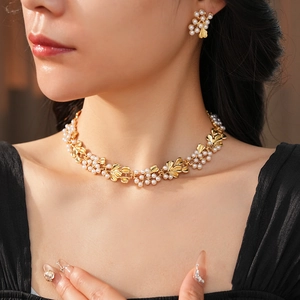 Close-up of vintage flower and pearl jewelry set worn by model in soft lighting