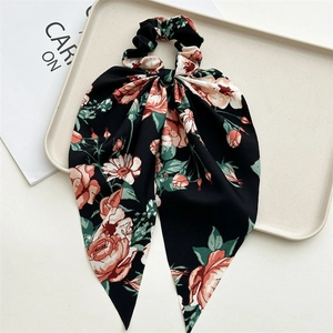 Detailed view of large floral scrunchie with streamers in black and red fabric