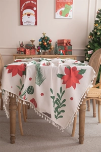 Detailed view of beige Christmas tablecloth with red poinsettias and white fringe