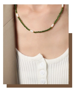 Détails des perles vertes et pierres blanches sur un collier de perles vintage