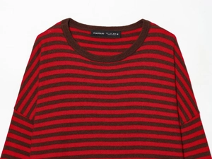 Vue détaillée du col rond et de l'étiquette d'un pull en maille rayé rouge et marron