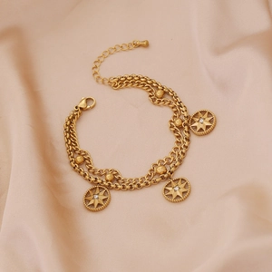 Close-up of double-layered gold chain bracelet with sparkling octagram star charms