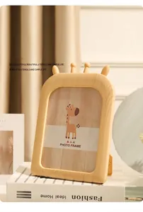 Détail d'un cadre photo créatif de 7 pouces en bois girafe posé sur des livres blancs
