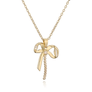 Luxurious gold-plated bow pendant necklace with sparkling zircons on white background
