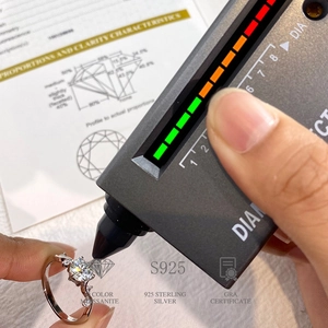 Diamond tester verifying moissanite stone on 925 sterling silver six-prong ring with GRA card