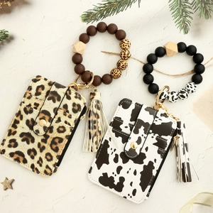 Detailed view of leopard and cow print wallet wristlets with silicone beads and tassels