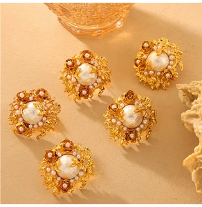 Detail of baroque pearl flower earrings with vintage gold petals and intricate floral design