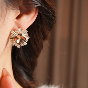 Vue macro des boucles d'oreilles soleil avec pierre ambre et cadre en zircone