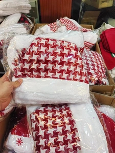 Detail view of a red and white houndstooth Christmas hat in transparent packaging