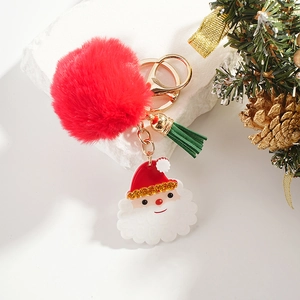 Detail of Santa Claus keychain with red pompom, green tassel, and golden metal ring