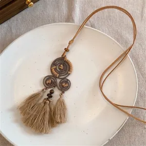 Sautoir bohème avec pompons en soie et perles en bois sur cordon en daim beige
