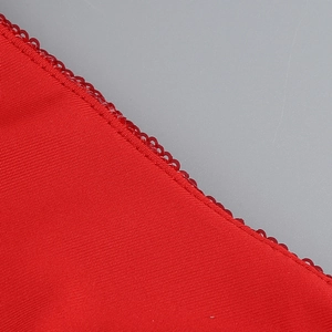 Detailed view of the red elegant fabric texture and wavy edge stitching on the formal gown
