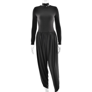 Detail of black long sleeve jumpsuit featuring slim fit bodice and harem style trousers