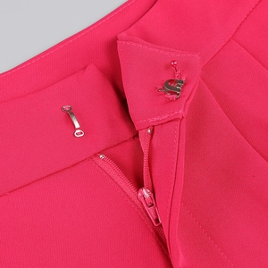 Detailed macro view of the metal hook and zipper closure on rose pink suit trousers