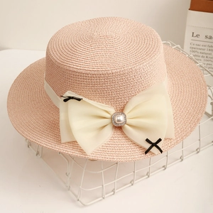 Pink flat top straw hat for women featuring cream chiffon bow and faux pearl detail
